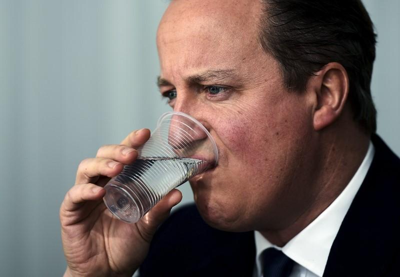 British Prime Minister David Cameron sips some water at a meeting with Italian Prime Minister Matteo Renzi (unseen) during a European Union leaders summit in Brussels
