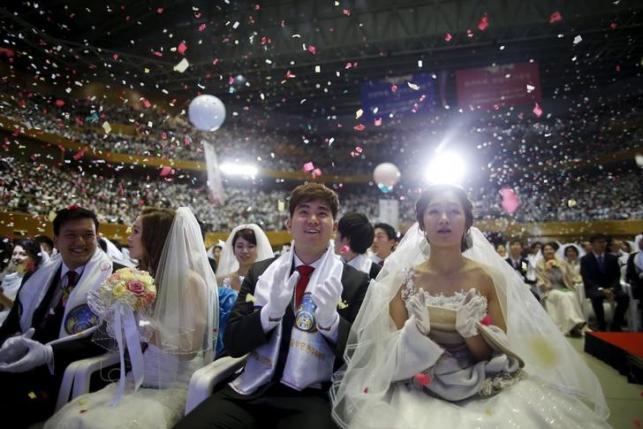A newlywed couple celebrates during a mass wedding ceremony of the Unification Church at Cheongshim Peace World Centre in Gapyeong