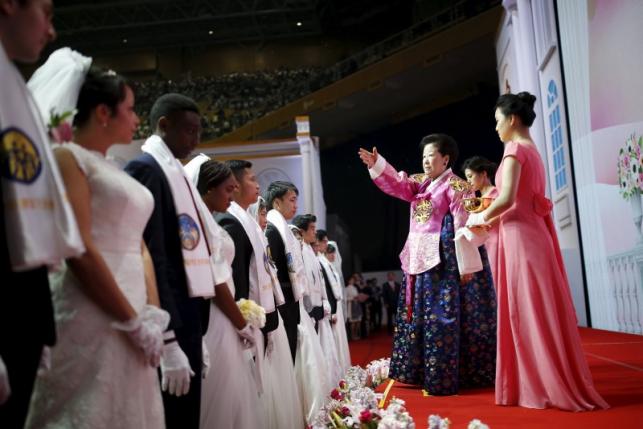 Han Hak-ja sprays holy water to bless newlywed couples during a mass wedding ceremony of the Unification Church at Cheongshim Peace World Centre in Gapyeong