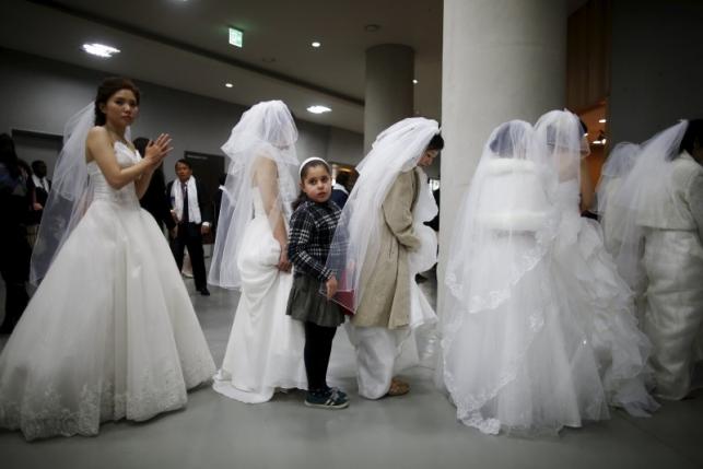 A girl queues to get to a toilet with brides during a break in a mass wedding ceremony of the Unification Church at Cheongshim Peace World Centre in Gapyeong