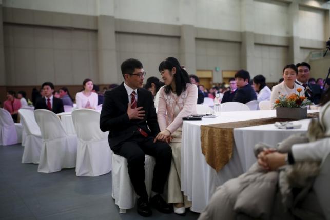 An international couple holds hands during an orientation for upcoming mass wedding ceremony of the Unification Church at a resort in Yangpyeong