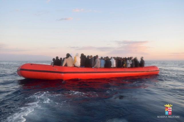 Marina Militare handout photo shows migrants sitting in their boat during a rescue operation by Italian naval vessel Bettica