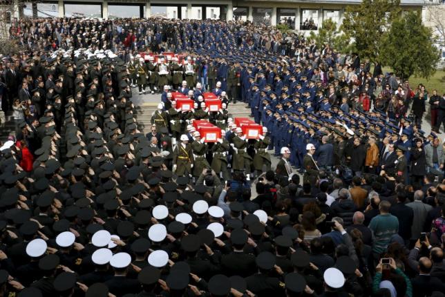 Honour guards carry Turkish flag-draped coffins of car bombing victims during a funeral ceremony at Kocatepe mosque in Ankara
