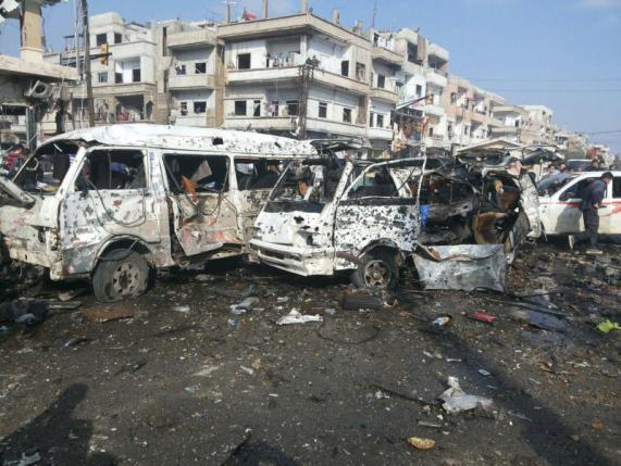 Damaged buses are seen at the site of two bomb blasts in the government-controlled city of Homs
