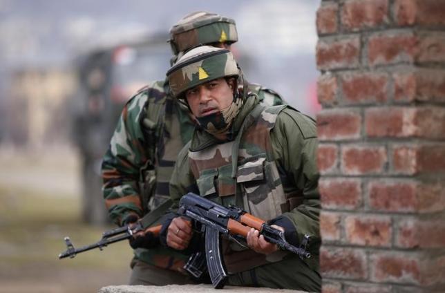 Indian army soldiers take their positions near the site of a gunbattle on the outskirts of Srinagar