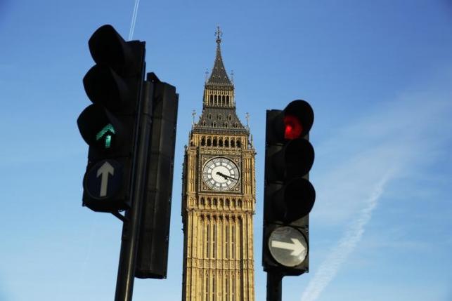 Red and green traffic lights direct traffic in front of the Big Ben bell tower at the Houses of Parliament  in London, Britain