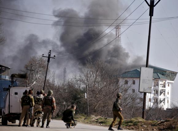 Smoke billows from a building, in which Indian authorities say suspected militants are holed up, during a gun battle on the outskirts of Srinagar