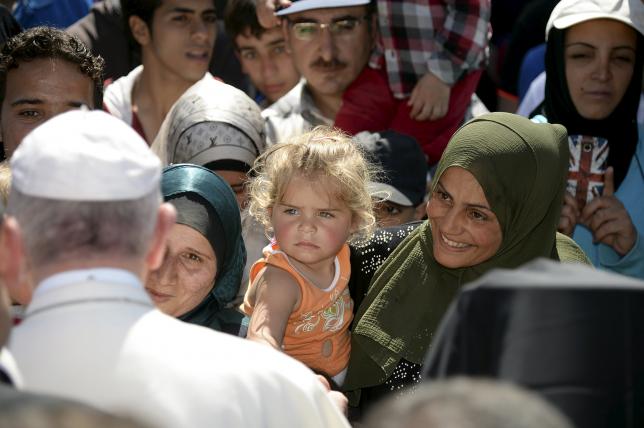 Pope Francis greets migrants and refugees at the Moria refugee camp near the port of Mytilene, on the Greek island of Lesbos