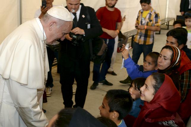 Pope Francis greets migrants and refugees at the Moria refugee camp near the port of Mytilene, on the Greek island of Lesbos