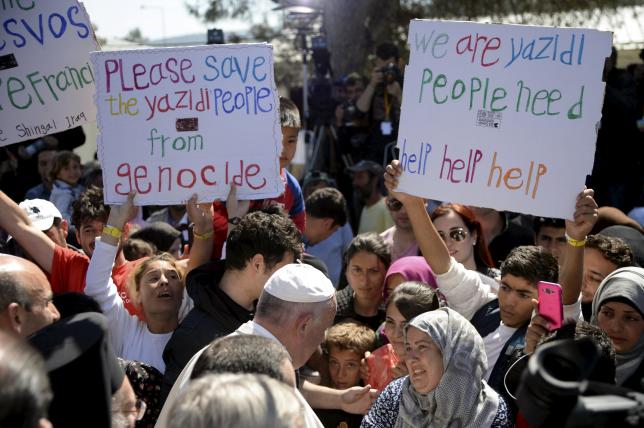 Pope Francis greets migrants and refugees at the Moria refugee camp near the port of Mytilene, on the Greek island of Lesbos