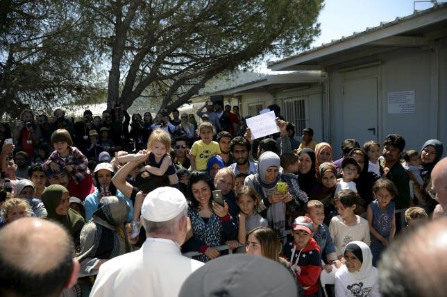 Pope Francis greets migrants and refugees at the Moria refugee camp near the port of Mytilene, on the Greek island of Lesbos