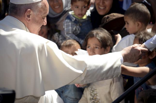 Pope Francis greets migrants and refugees at the Moria refugee camp near the port of Mytilene, on the Greek island of Lesbos