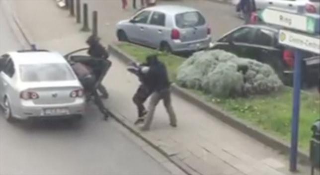 Police officers detain a suspect during a raid in which fugitive Mohamed Abrini was arrested in Anderlecht in this still image taken from video