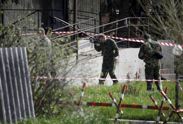 Investigators work near the entrance of a police station, which was recently attacked, in a settlement of the Novoselitsky district in Stavropol region, southern Russia