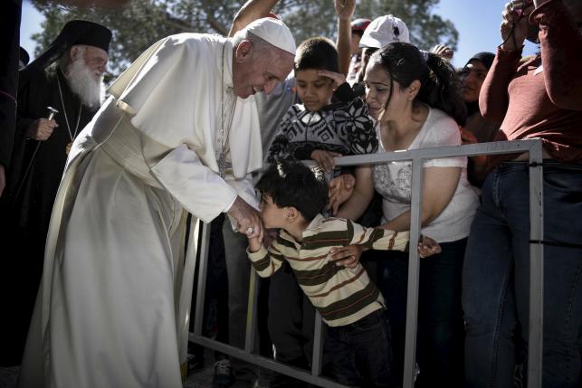 Handout photo of a boy shaking the hand of Pope Francis as he greets migrants and refugees at Moria refugee camp near the port of Mytilene, on the Greek island of Lesbos