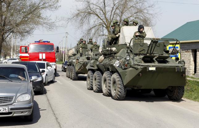 Servicemen of the Russian armed forces ride on armoured vehicles in a settlement of the Novoselitsky district, where a local police station was recently attacked, in Stavropol region, southern Russia