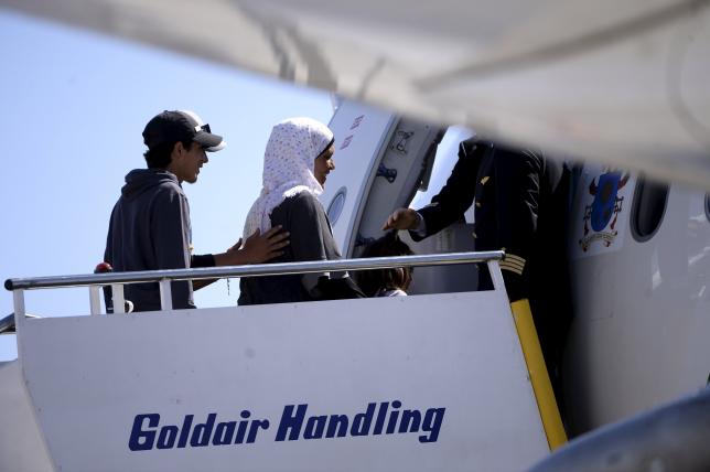 A group of Syrian refugees board a plane with Pope Francis at the airport of Mytilene, in the Greek island of Lesbos