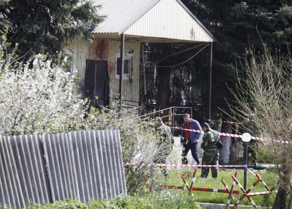 Investigators work near the entrance of a police station, which was recently attacked, in a settlement of the Novoselitsky district in Stavropol region, southern Russia