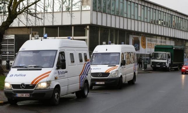 A Police officer stands in front of a car dearlership during a police operation after fugitive Mohamed Abrini was arrested in Anderlecht