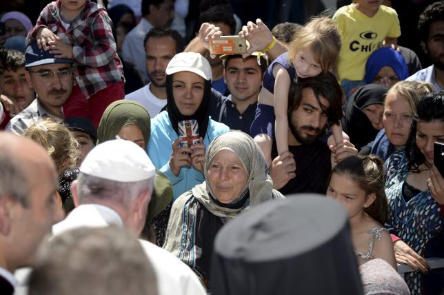 Pope Francis greets migrants and refugees at the Moria refugee camp near the port of Mytilene, on the Greek island of Lesbos