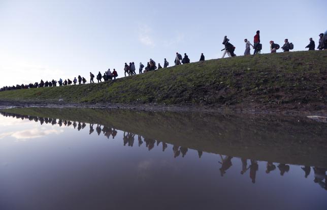 Migrants make their way on foot on the outskirts of Brezice