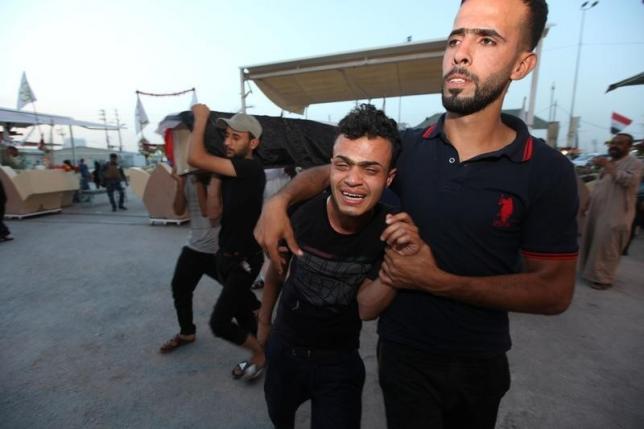 Mourners react during a funeral of a victim who was killed in a bomb attack in Baghdad