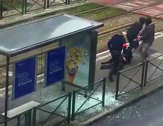 Belgian police drag a suspect along a tramway platform, in this still image taken from amateur video, after the suspect was shot, in the Brussels borough of Schaerbeek, following Tuesday's bombings in Brussels, Belgium