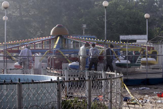 Forensic officers look for evidence at the site of a blast that happened outside a public park on Sunday, in Lahore