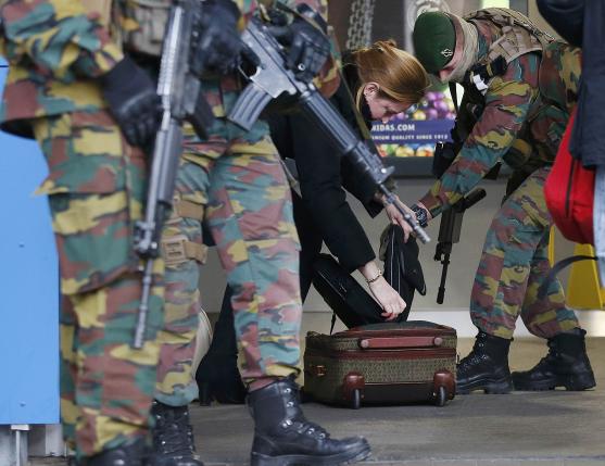 A woman's baggage is searched by soldiers at the entrace to a Brussels subway station following Tuesday's bombings in Brussels.