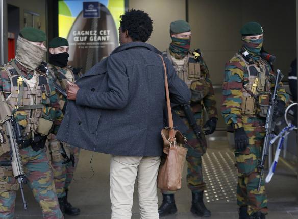 A man is searched by soldiers at the entrace to a Brussels subway station following Tuesday's bombings in Brussels.