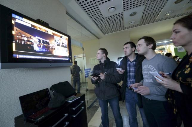 Journalists watch news on crashed Flydubai Boeing 737-800 at airport of Rostov-On-Don