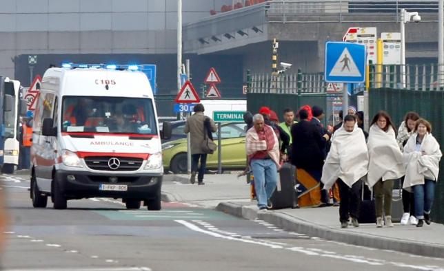 People wrapped in blankets leave the scene of explosions at Zaventem airport near Brussels, Belgium