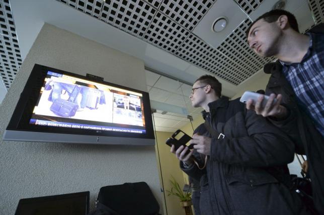 Journalists watch news on crashed Flydubai Boeing 737-800 at airport of Rostov-On-Don