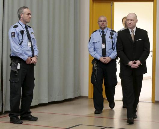 Mass killer Anders Behring Breivik is escorted by prison guards as he arrives at the court room in Skien prison