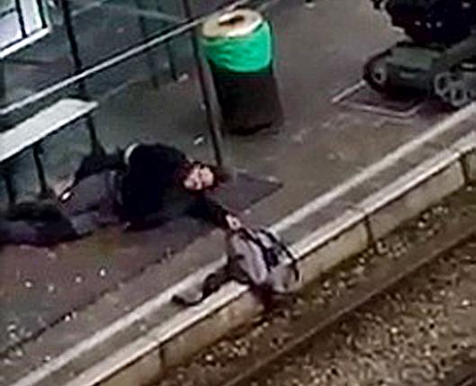 A suspect lies on the platform of a tramway station, in this image taken from amateur video, after he was shot and wounded by police in the Brussels borough of Schaerbeek, following Tuesday's bombings in Brussels,