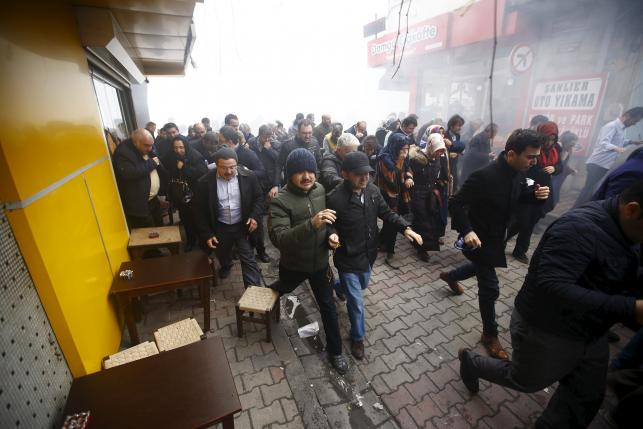 Riot police use tear gas to disperse protesting employees and supporters of Zaman newspaper at the courtyard of the newspaper's office in Istanbul