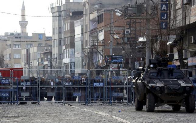 File photo of people standing behind the security barriers in the Kurdish-dominated southeastern city of Diyarbakir