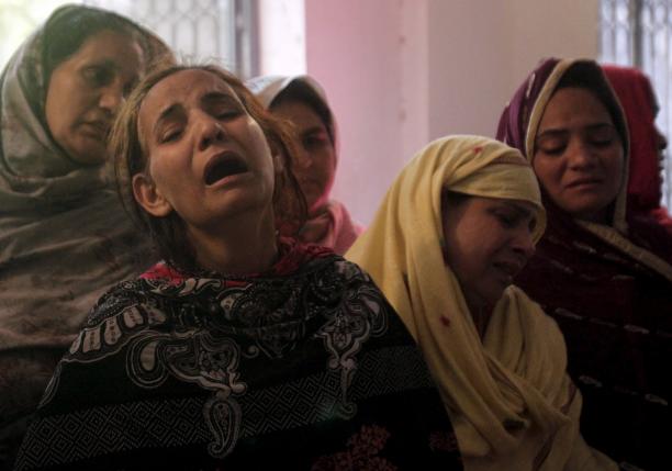 Family members mourn the death of a relative, who was killed in a blast that happened outside a public park on Sunday, in Lahore