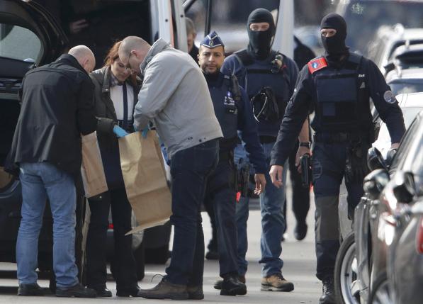 Police look at bags of evidence material during a search in the Brussels borough of Schaerbeek following Tuesday's bombings in Brussels.