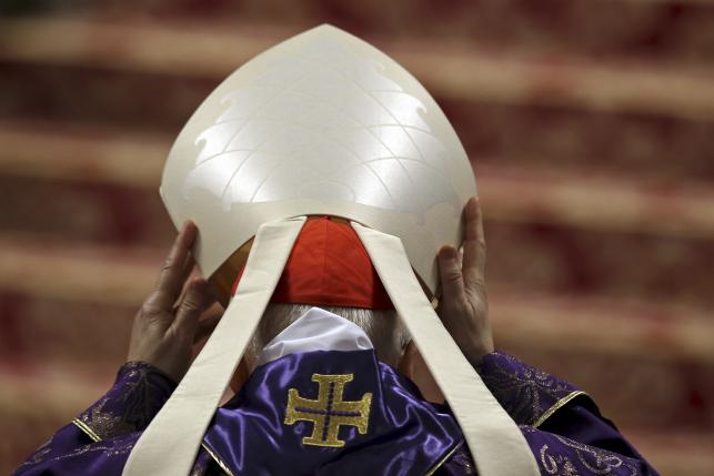 File photo of a Cardinal lifts his hat as Pope Francis leads the Ash Wednesday mass, in St. Peter's Basilica at the Vatican