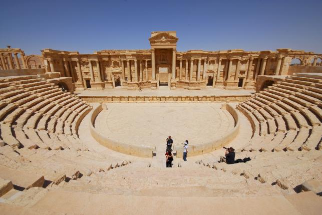File photo of tourists taking pictures at the ancient Palmyra theater in the historical city of Palmyra