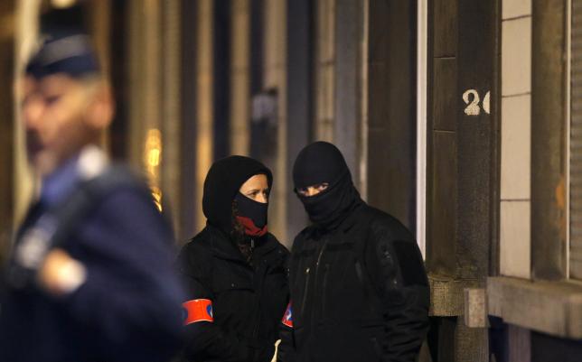 Masked Belgian police secure the entrance to a building in Schaerbeek during police operations  in Brussels