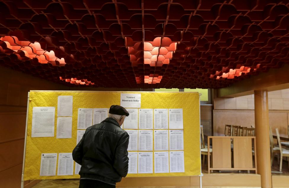 A voter checks the list of candidates before casting his ballot at a polling station during the country's parliamentary election in Ruzindol