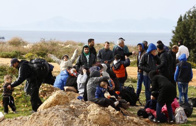Syrian refugees wait on a roadside after Turkish police prevented them from sailing off to the Greek island of Farmakonisi by dinghies, near a beach in the western Turkish coastal town of Didim