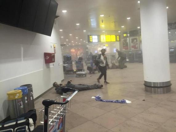 An injured man lies at the scene of explosions at Zaventem airport near Brussels