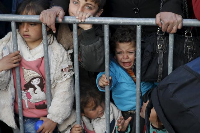 Migrants wait to cross the Greek-Macedonian border at a makeshift camp, near the village of Idomeni