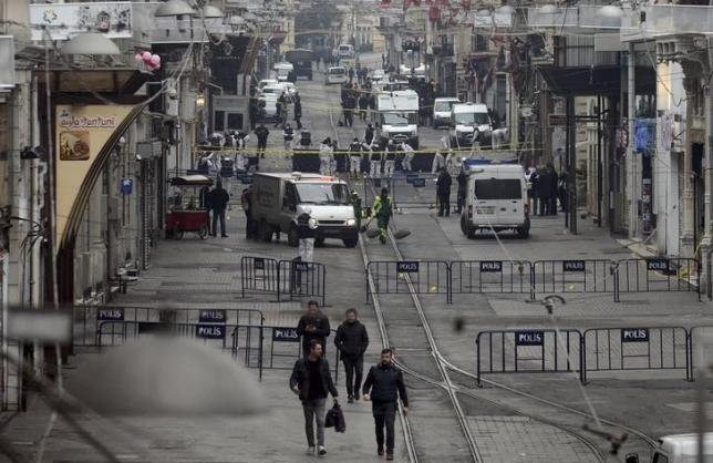Police forensic experts inspect the area after a suicide bombing occured in a major shopping and tourist district in central Istanbul, Turkey