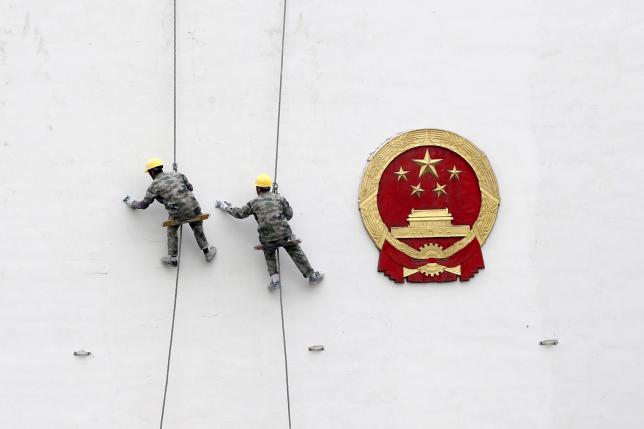 File picture of workers painting a wall of a government building in Hangzhou