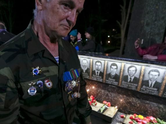 A man visits at a memorial, dedicated to firefighters and workers who died after the Chernobyl nuclear disaster, during a night service in the city of Slavutych