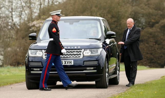 A U.S. Marine passes in front of Queen Elizabeth II as she waits in her car to greet U.S. President Barack Obama and first lady Michelle Obama upon their arrival for lunch at Windsor Castle in Windsor